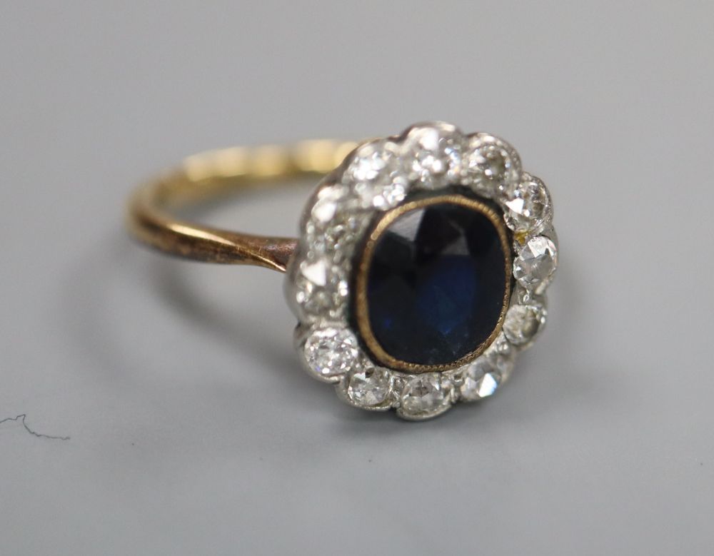 A 1940s/1950s? yellow metal, sapphire and diamond set oval cluster ring, size I/J, gross 3 grams.
